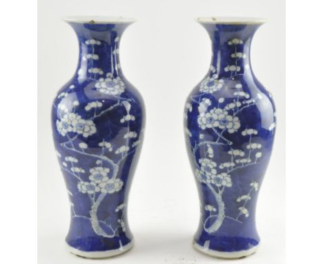 A pair of late Qing blue and white prunus vases. Each flared mouth vase decorated with blossoming prunus and branches, chips 