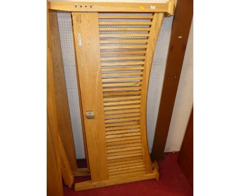 A contemporary light oak slatted kingsize double bedstead, having side rails and loose slatted base section