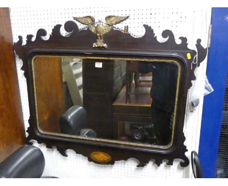 An early 20th century Chippendale style fret cut rectangular bevelled wall mirror, having a floral shaped outline  with eagle