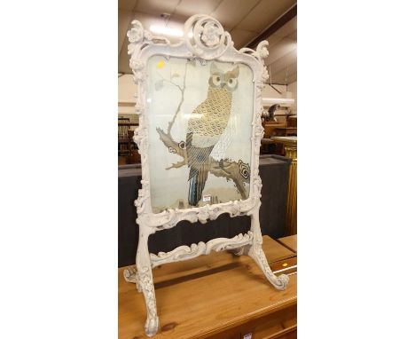 A 19th century Rococo Revival and later white painted carved and floral decorated fire screen, with silkwork inset of an owl,