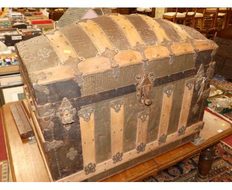 An early 20th century wood, canvas and metal bound domed hinge top travelling trunk, width 92cm