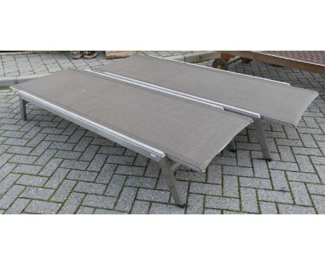 A pair of contemporary teak aluminium clad and canvas inset sun loungers, each with ratchet mechanism, length 195cm 