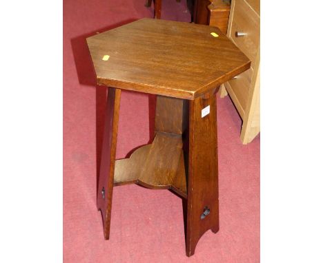 An Arts &amp; Crafts oak hexagonal occasional table, raised on tapering supports to platform undertier, h.60.5cmSome light ma