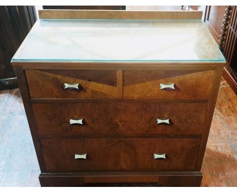 An Art Deco walnut chest of drawers, circa 1930, rectangular top with a glazed top with quarter gallery to the back, two shor