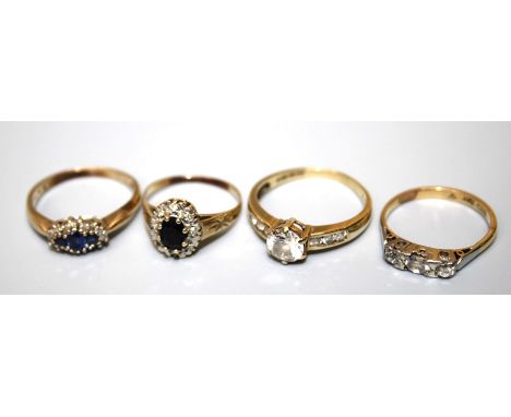 A three stone sapphire ad diamond cluster ring; a three stone half hoop diamond ring, a garnet cluster ring and one other rin