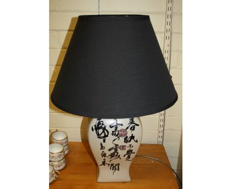 A decorative Chinese pottery table lamp decorated with script and marks in seal. to the rectangular section body. Together wi