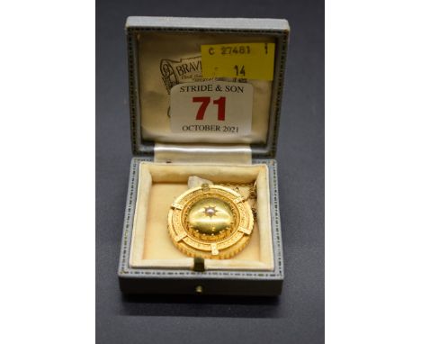A Victorian yellow metal circular brooch, set central pearl and locket to back, stamped 15ct, 3.2cm. 