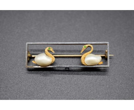 A yellow metal rectangular brooch, decorated two swans with pearl bodies and emerald set eyes, stamped 15ct, 37.5cm wide, gro