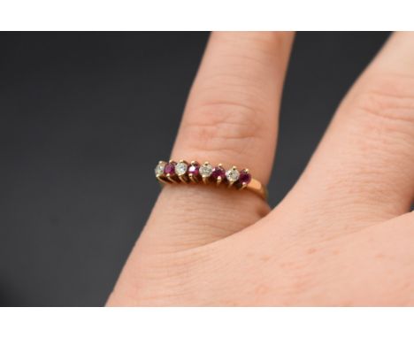 A yellow metal ruby and diamond eight stone ring, stamped 14k 585, size N, 2.3g gross weight. 