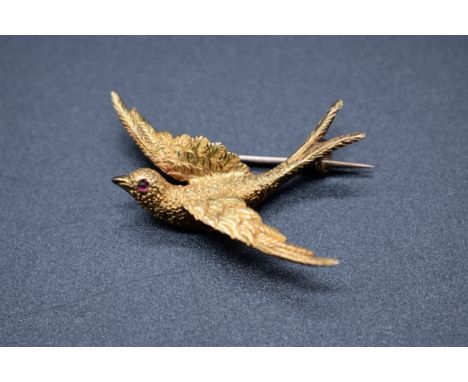 A yellow metal bird brooch,&nbsp;with ruby set eye,&nbsp;stamped 15ct, 33mm, gross weight 2.9g. 