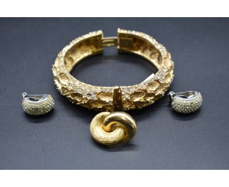 A vintage Christian Dior gold plated hinged bangle; together with a pair of Dior ear clips; and another Dior ear clip. 