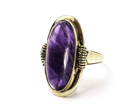 A retro 14ct gold and amethyst dress ring, the large oval cabuchon purple stone in an ornate mount, marked 585 and Handarbeit