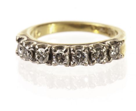 A seven stone diamond half hoop eternity ring, the row of uniform brilliant cuts totalling approx 1ct, presented in claw sett