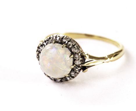 An opal and diamond dress ring, the cluster mount having a round cabuchon opal surrounded by a band of rose cuts on a yellow 