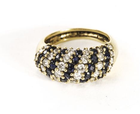 A pretty 18ct gold and gem set bombe dress ring, the bulging tablet set with angled columns of round cut sapphire and brillia