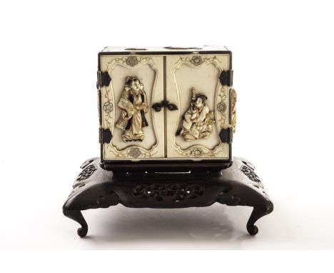 A fine 19th century Japanese Shibayama style miniature tansu, the rectangular ivory chest with carved figures to the two fron