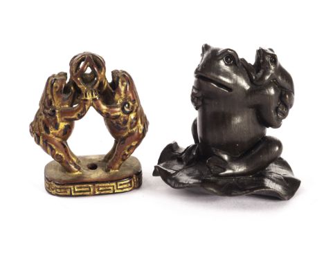 An ebony netsuke modelled as a frog and young on a lily pad with signature to the base, together with an unusual painted and 