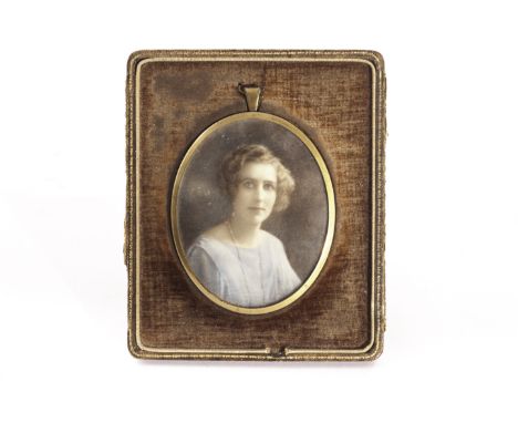 An Edwardian portrait miniature, the oval gold plated frame having a portrait of a lady, possibly on ivory, in damaged fitted