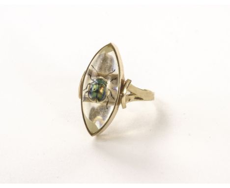 A continental gold and insect dress ring, the navette shaped mount supporting a glass panel with inset bright coloured beetle