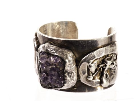 A modern Swedish white metal and amethyst bangle by Jacob Hull, the heavy cuff bracelet mounted with a piece of natural purpl