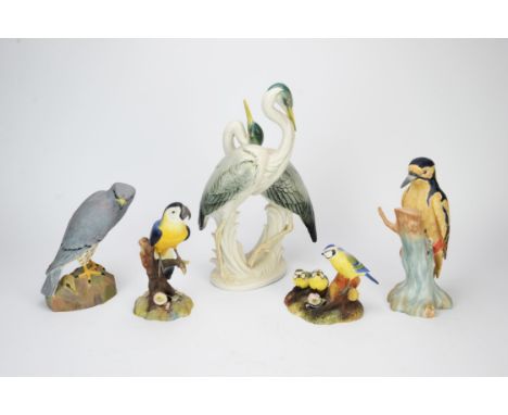 German porcelain model of a pair of heron, 20th Century, together with two Royal Crown Derby models of blue tits and a parrot