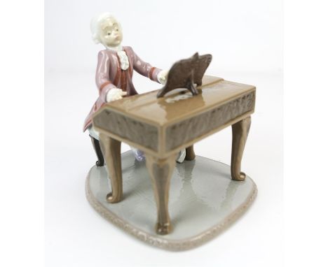 A Lladro porcelain figure of Mozart at his piano, in a lilac frock coat, underside bearing Lladro printed mark, impressed sta