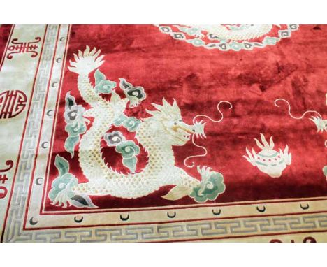 MID 20TH CENTURY CHINESE FRINGED CARPET
in shades of red on cream with dragon designs, 272cm wide