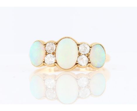 An 18ct yellow gold opal and diamond ring, set with three oval opal cabochons, interspersed with four old cut diamonds, hallm