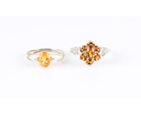 A citrine ring, stamped 925, together with a fire opal ring with a colourless stone set either side of the central stone, rin