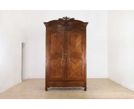 A Louis XV provincial chestnut armoire,  mid-18th century, French or Swiss, the double-arched cornice over a pair of panelled