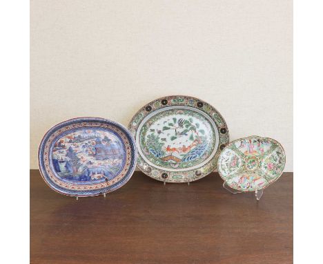 A Chinese clobbered plate,18th century, of oval form, painted with a landscape,35.6cm long, and two Canton enamelled famille 
