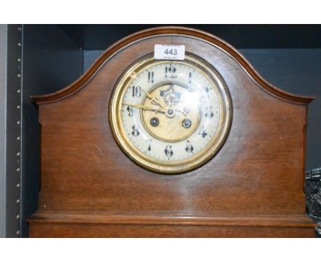 An antique mahogany cased mantle clock with a brass and enamel faced dial