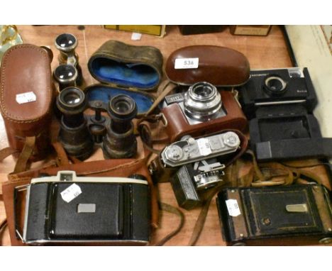 A collection of vintage cameras and binoculars including Kodak Instamatic, Kodak Synchro-Compur and more.