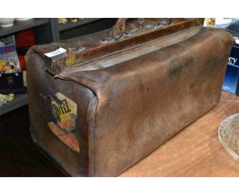 A vintage leather Gladstone bag having remains of advertising stickers to ends.good condition with minor age related wear in 