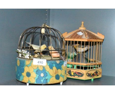 A mid century automaton of a bird cage and a similar wooden bodied example.
wind up example works,other one takes batteries a