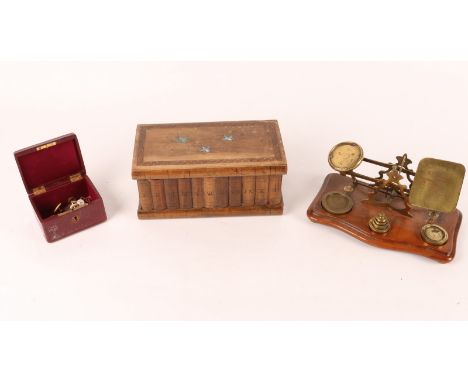 A MIDDLE EASTERN OLIVE WOOD SEWING BOX in the form of a row of books with swallow decoration, 24cm wide, a set of brass posta
