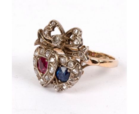 A ruby, sapphire and diamond ring, converted from a 19th Century sweetheart brooch, modelled as twin hearts beneath a bow, 9c