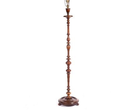 A standard lamp of turned form on a circular base with ball feet, 106cm high