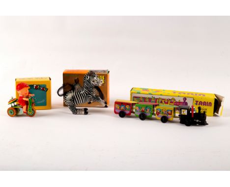 A tin plate jumping zebra M5505, 13cm long, a ringing tricycle, 10cm long and a train engine with three linked carriages, 25.