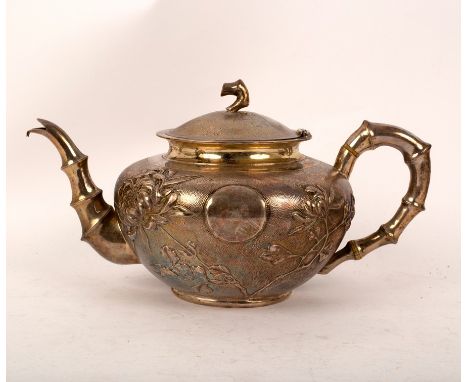 A Chinese export silver teapot, circa 1900, with faux bamboo handle, spout and finial, the sides decorated chrysanthemums, 12