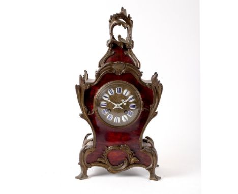 A 19th Century French tortoiseshell and gilt metal mounted mantel clock with C-scroll decoration, the gilt dial with porcelai