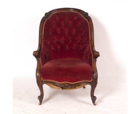 A Victorian mahogany armchair with button back, the frame acanthus scrolls and bell drops with scroll arms on cabriole legs C