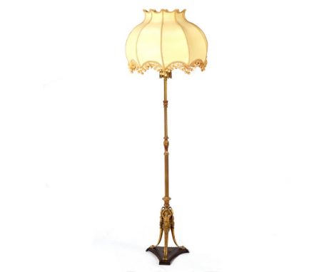 A brass standard lamp of reeded and twisted column form on a tripod base of female monopodiae CONDITION REPORT: The lamp shad
