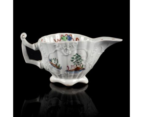A Worcester fluted creamboat, circa 1752-53, the thin angular handle with a pronounced thumb rest, the finely moulded cartouc