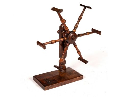 A fruitwood wool winder with spindle turned supports and square base, 43cm wide, a circular brass tray embossed a coat of arm