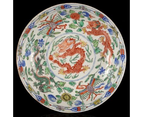 A Worcester saucer dish, circa 1775, after a Chinese famille verte original, the centre painted with a red dragon chasing a f