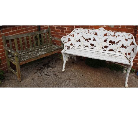 A cast iron white painted garden bench and a weathered wooden garden bench