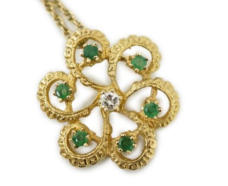 A modern yellow metal, emerald and diamond set stylised flower head pendant, 25mm, on a 375 chain, 46cm, gross weight 6.7 gra