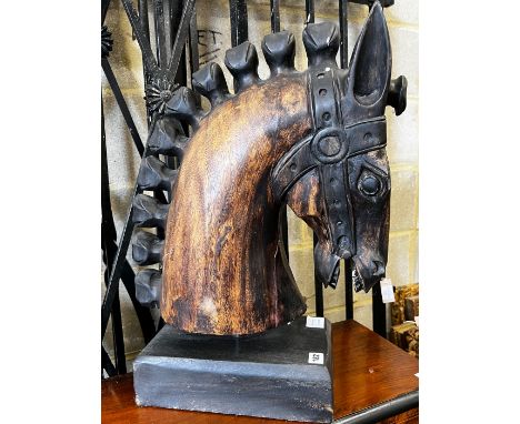 A stylised carved wood model of a horse's head on rectangular plinth, height 59cm