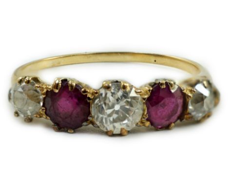 A yellow metal, three stone diamond and two stone ruby set half hoop ring, size V, gross weight 3.2 grams.